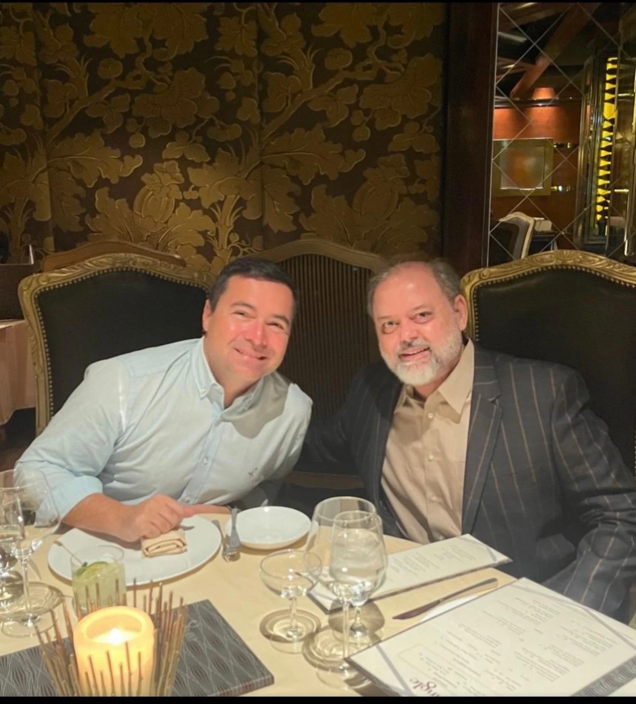Two men seated together at a restaurant table